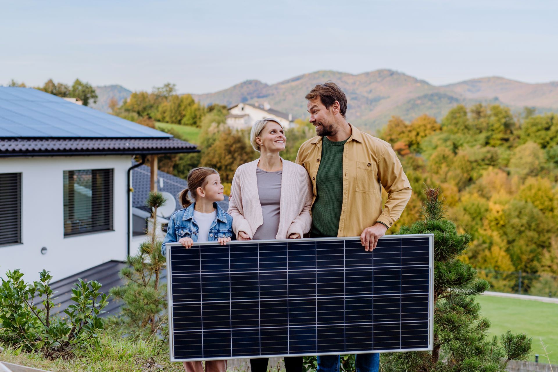 Familie hält ein Solarmodul in den Händen