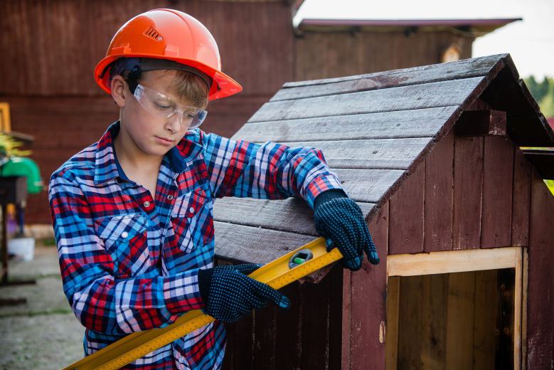 Kind als Bauarbeiter mit Wasserwaage